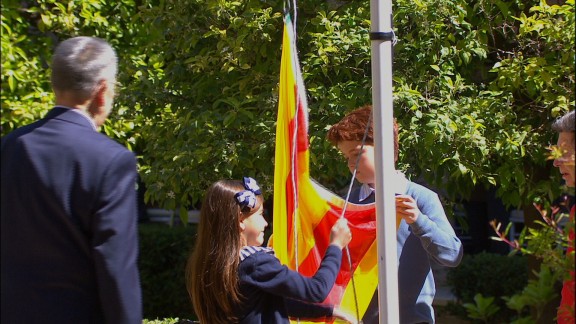 Dos hermanos y sus abuelos izan la bandera de Aragón en la celebración de San Jorge