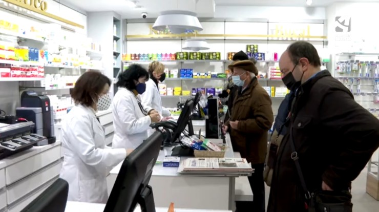 Tres clientes compran test de antígenos en una botica de Teruel.