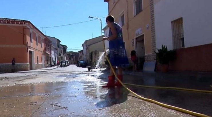Una vecina de Sena (Huesca) limpia una calle tras el paso de la DANA hace unas semanas.